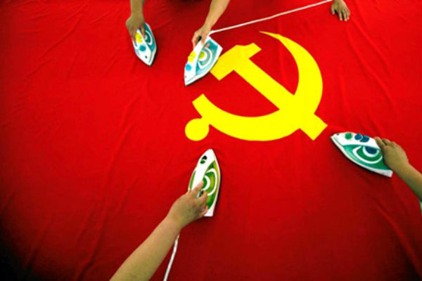 Pracownicy fabryki flag na przedmieściach Pekinu prasują flagę Komunistycznej Partii Chin | fot. REUTERS
