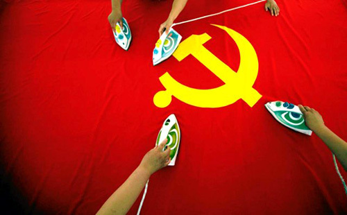 Pracownicy fabryki flag na przedmieściach Pekinu prasują flagę Komunistycznej Partii Chin | fot. REUTERS