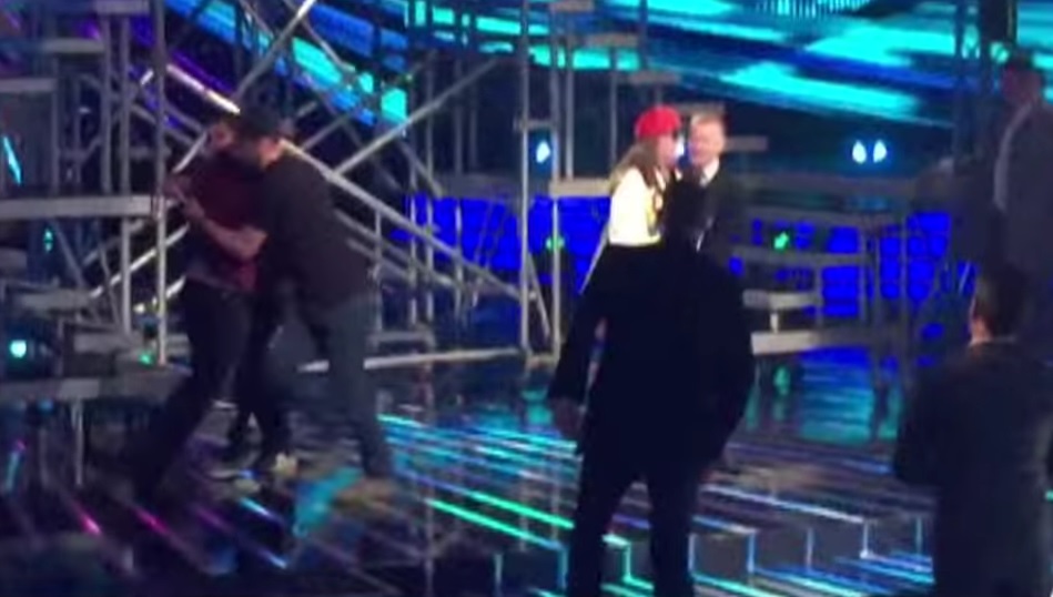 Grupa mężczyzn wtargnęła na scenę brytyjskiego "The X Factor" | fot. YouTube